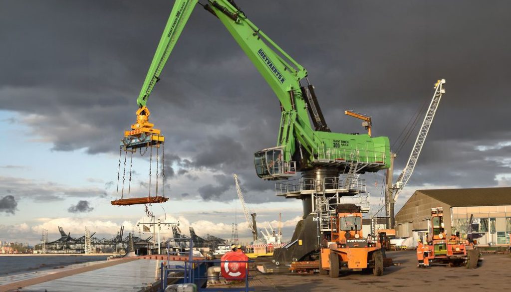 Groene havenkraan met grijper op kade — Goeyvaerts machinepark beheerd met AllConnects