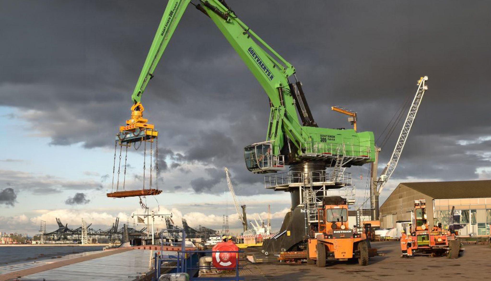 Groene havenkraan met grijper op kade — Goeyvaerts machinepark beheerd met AllConnects